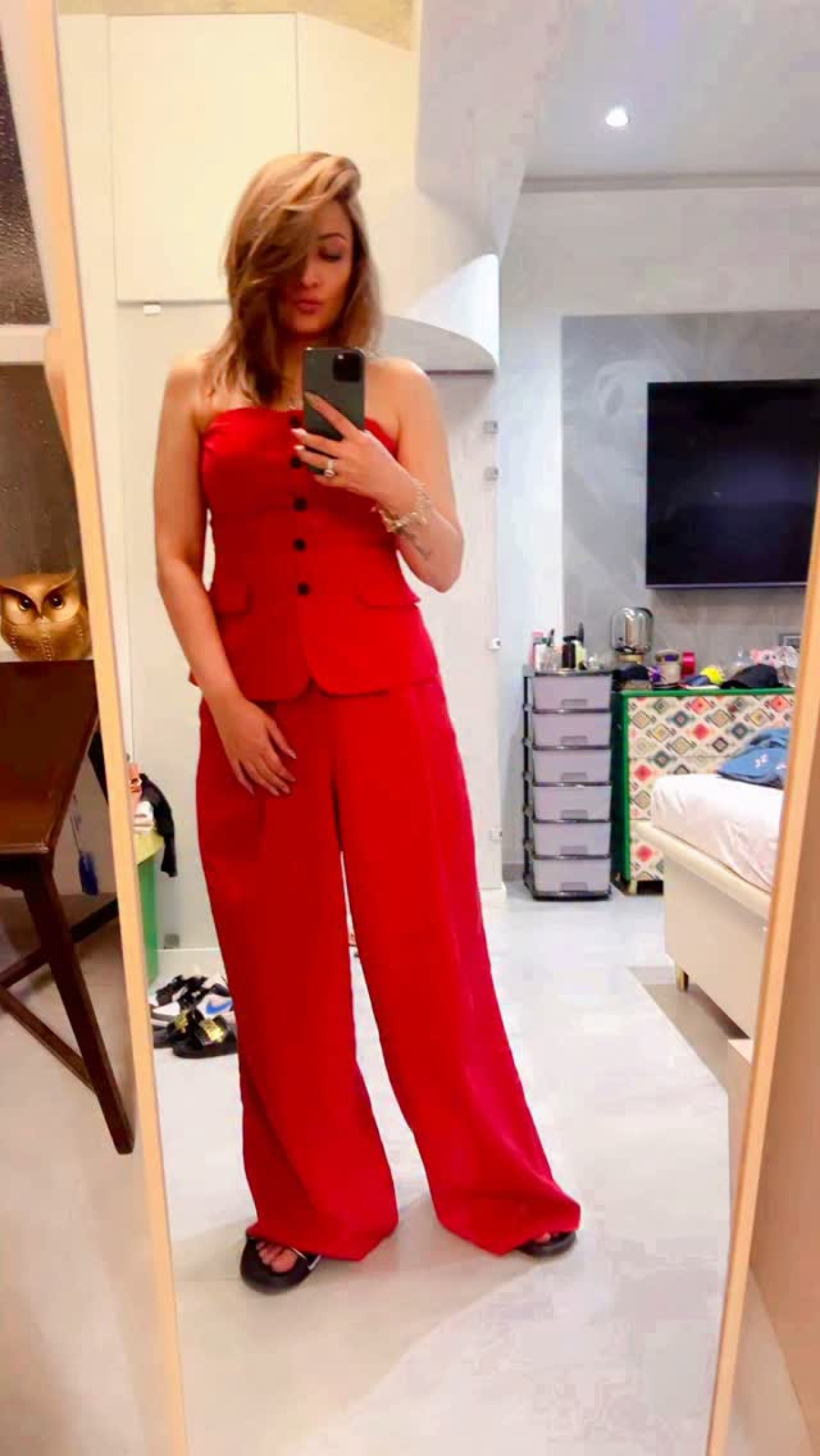 Celebrated TV icon revels in chic style and self-love during a vibrant red night out.